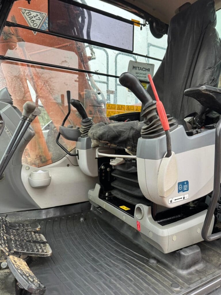 Excavator cabin interior with control levers and pedals