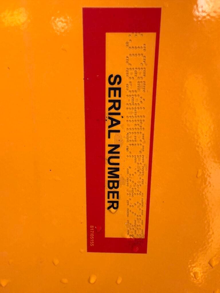 Serial number label with Braille on yellow surface