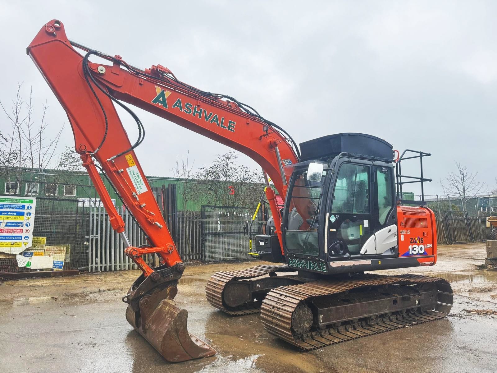 Orange excavator at construction site on cloudy day