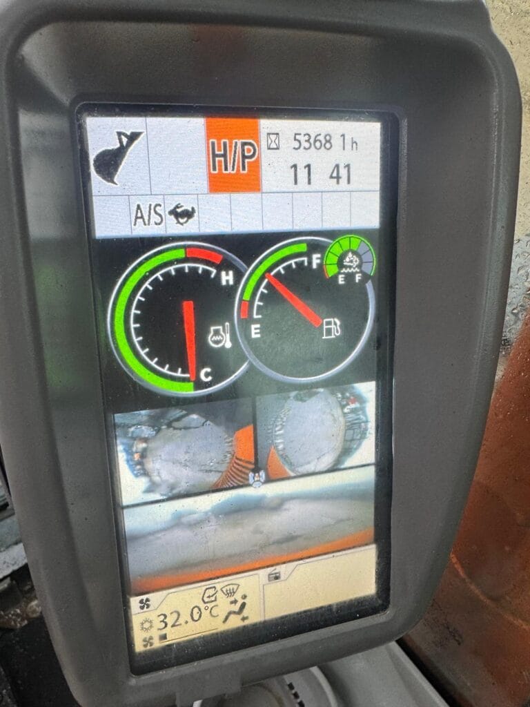 Vehicle dashboard display showing gauges and temperature