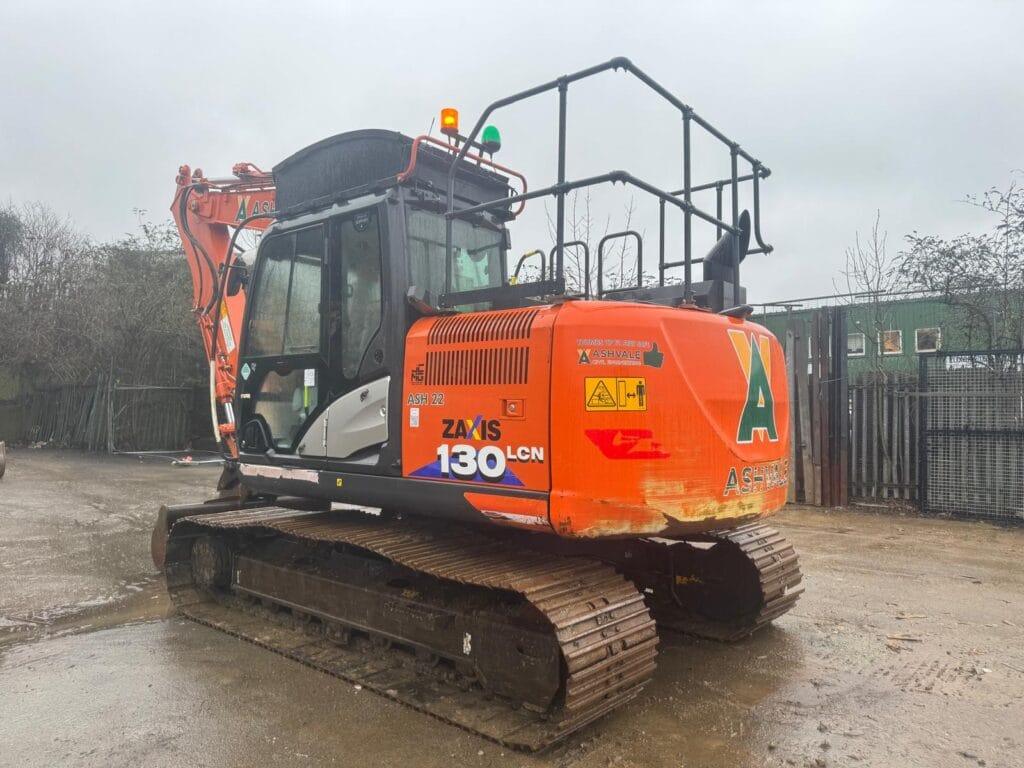 Orange excavator parked on wet construction site